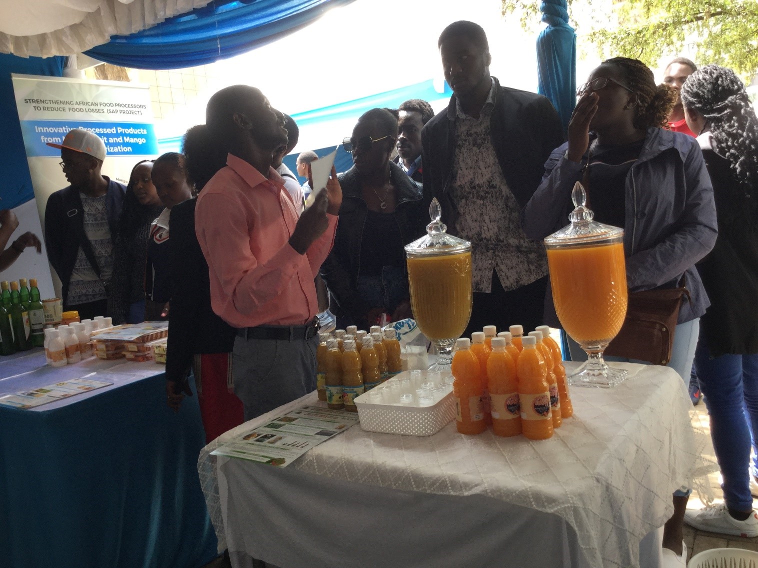 Innovator Mbusa Sikwaya (MSc Food Science) explains about his innovation (mango-moringa nectar) to the visitors